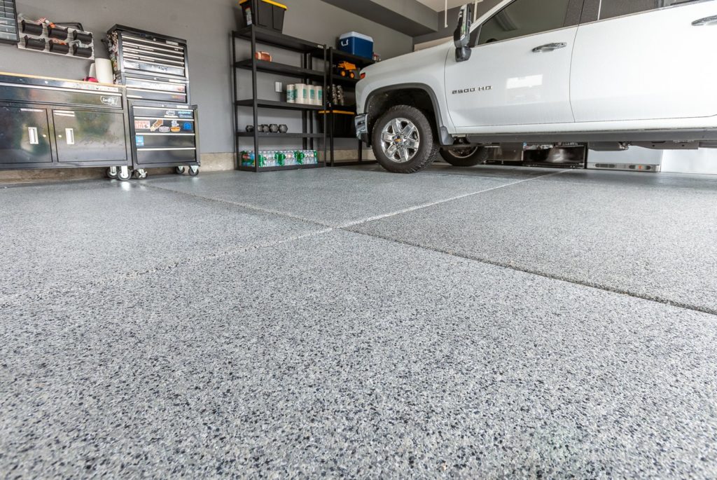 Modern garage floor coating with polyaspartic topcoat and flake finish
